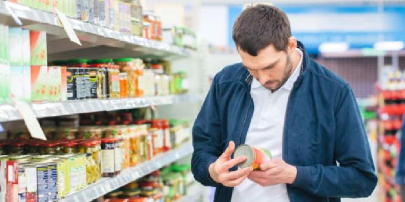 Foto van man die boodschappen doet en etiket goed leest