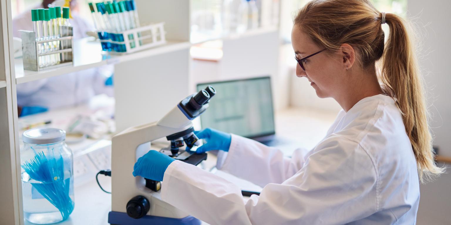 onderzoeker achter microscoop