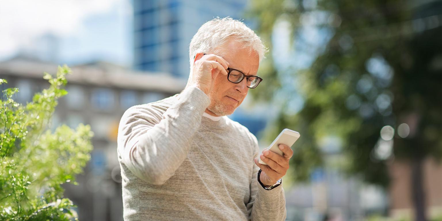 man kijkt op zijn mobiel
