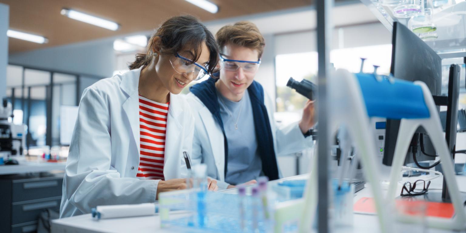 Twee jonge onderzoekers overleggen in het lab