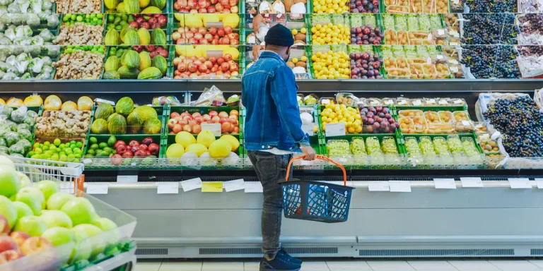 Man bij groente- en fruitschap in winkel