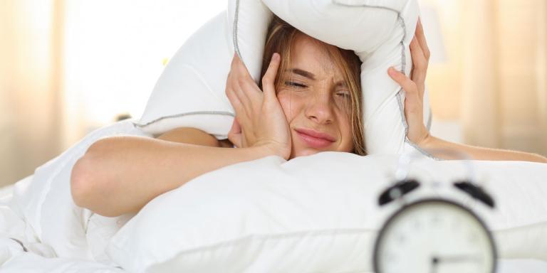 Foto: Vrouw met kussen over haar hoofd