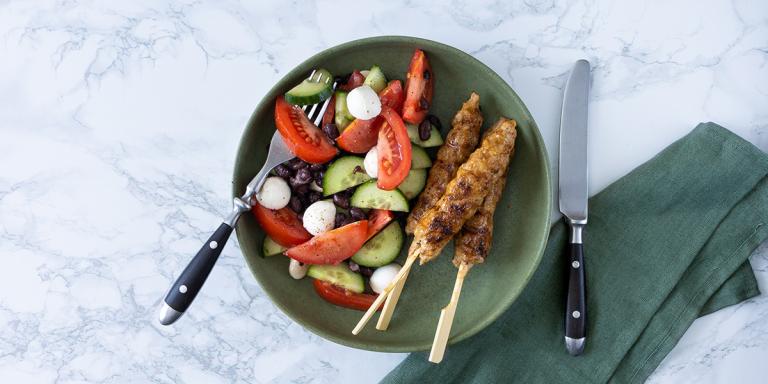 Drie kipspiesjes en salade van tomaten, komkommer, rode ui en bonen