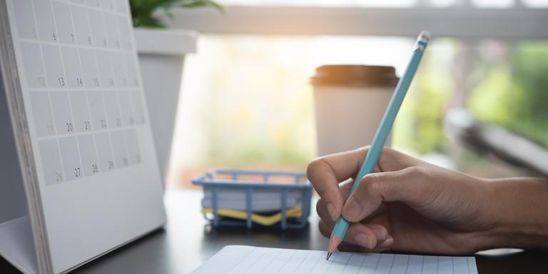 Kalender en potlood met notitieblok - Afspraak maken met de huisarts vanwege afkomst