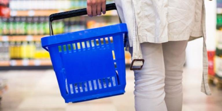 Vrouw in de supermarkt checkt producten op suiker en calorieën