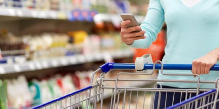 Vrouw zoekt naar suikervrije producten in de supermarkt