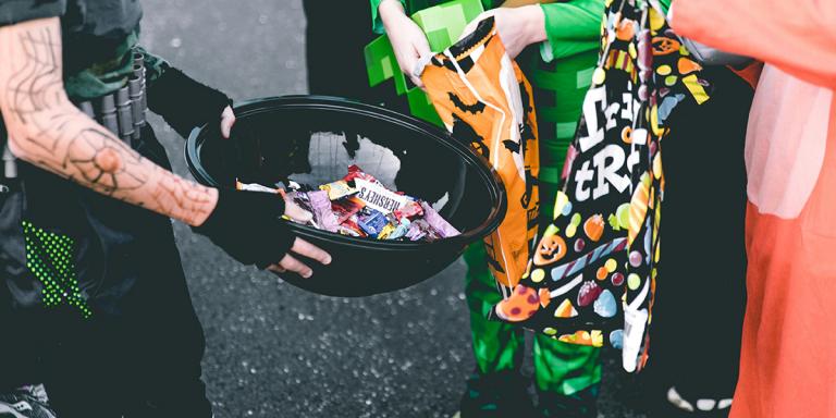 Iemand deelt snoep uit in zwarte schaal