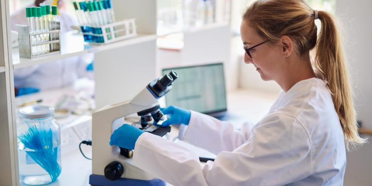 onderzoeker achter microscoop