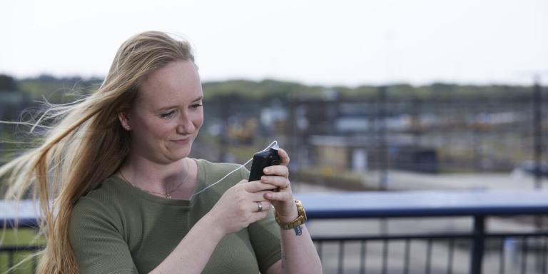 Jonge vrouw kijkt op haar insulinepomp