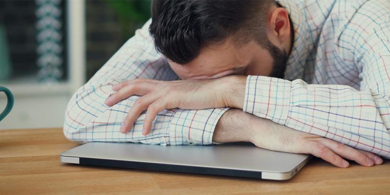 man ligt op dichte laptop