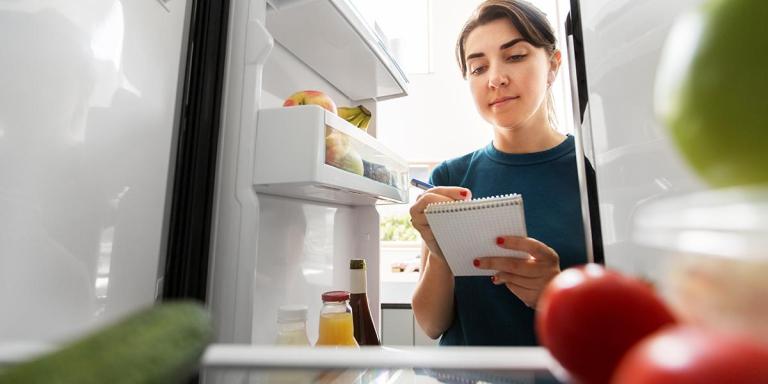 Vrouw checkt de koelkast op suiker