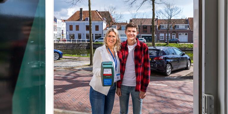 Twee collectanten Diabetes Fonds met collectebus aan de deur