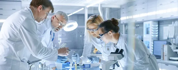 Wetenschappers in een laboratorium staan te werken bij een tafel