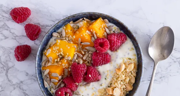 Chiapudding met mango, frambozen, macadamia, zonnebloempitten en hhennepzaad