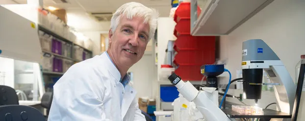 Professor Eelco de Koning zit aan een microscoop
