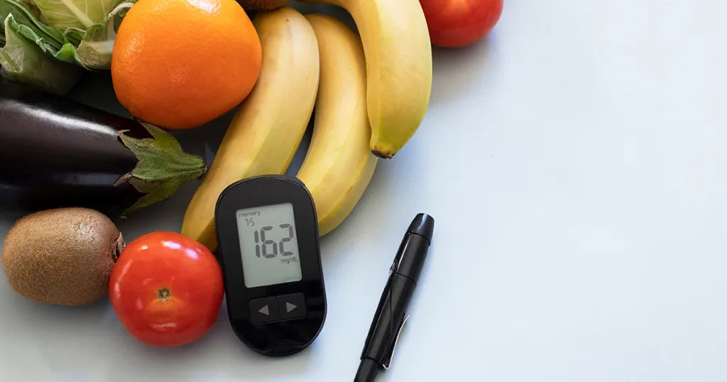 verschillende soorten groente  en fruit en een bloedglucosemeter