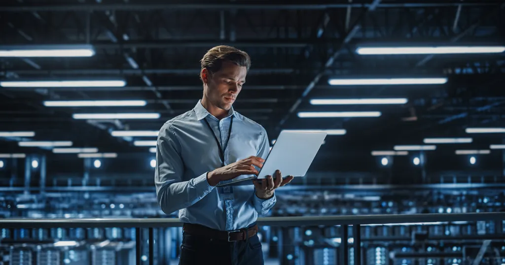 ICT-medewerker met laptop in groot datacenter