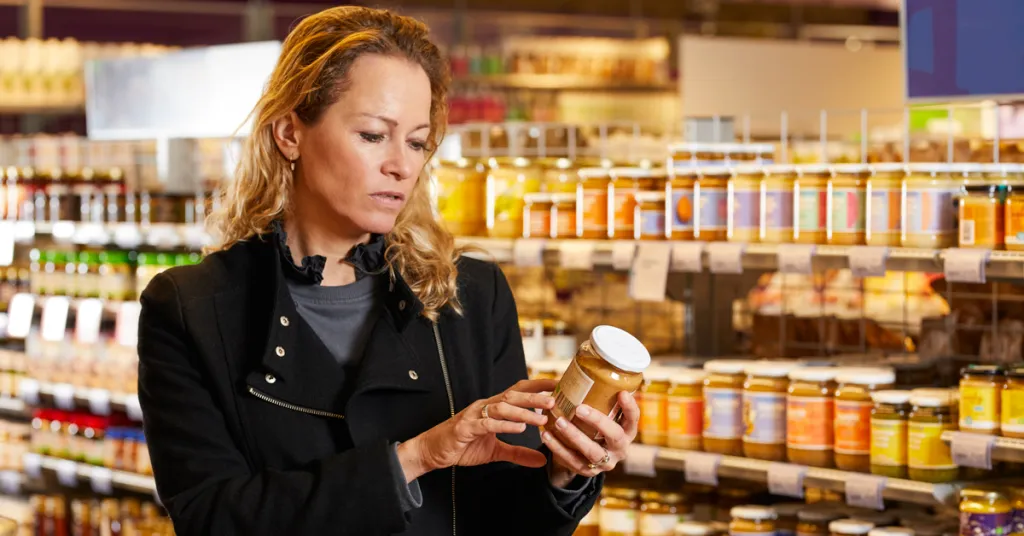 Vrouw in supermarkt checkt etiket op suiker