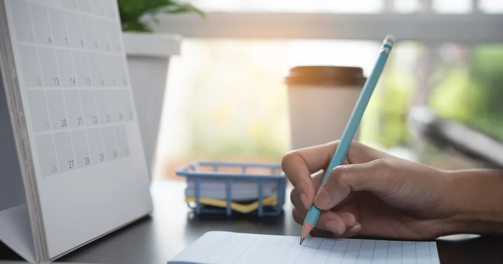 Kalender en potlood met notitieblok - Afspraak maken met de huisarts vanwege afkomst
