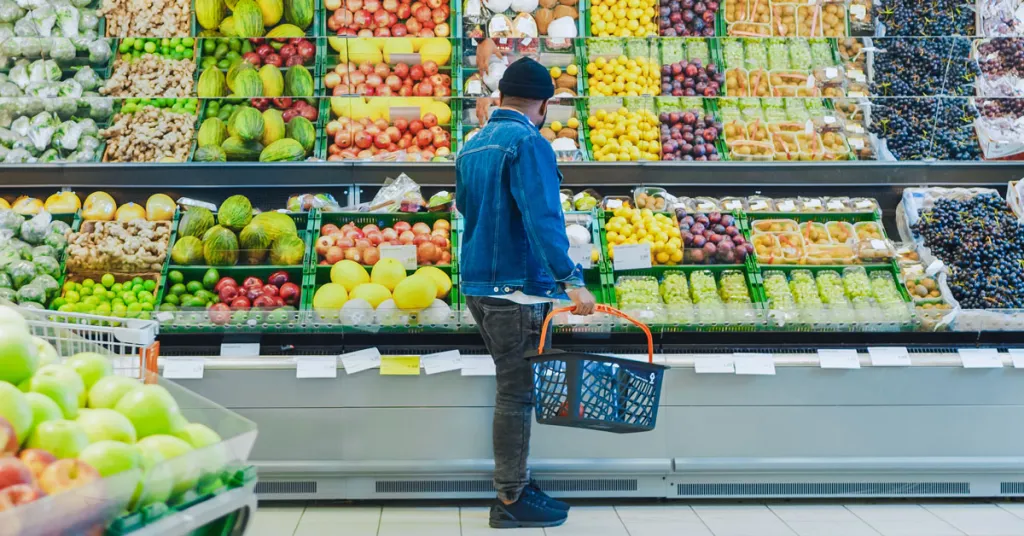 Foto man in de supermarkt die groenten uitzoekt