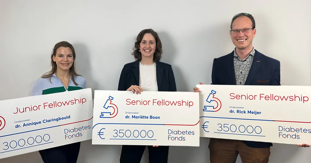 Drie fellows met cheque voor hun onderzoek