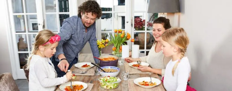 Gezin aan tafel eten gezond met minder suiker