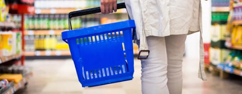 Vrouw in de supermarkt checkt producten op suiker en calorieën