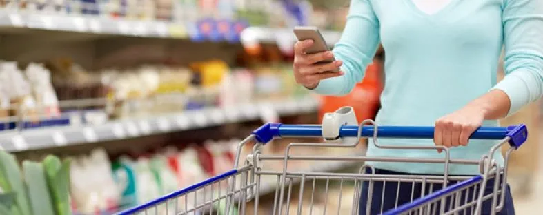 Vrouw zoekt naar suikervrije producten in de supermarkt