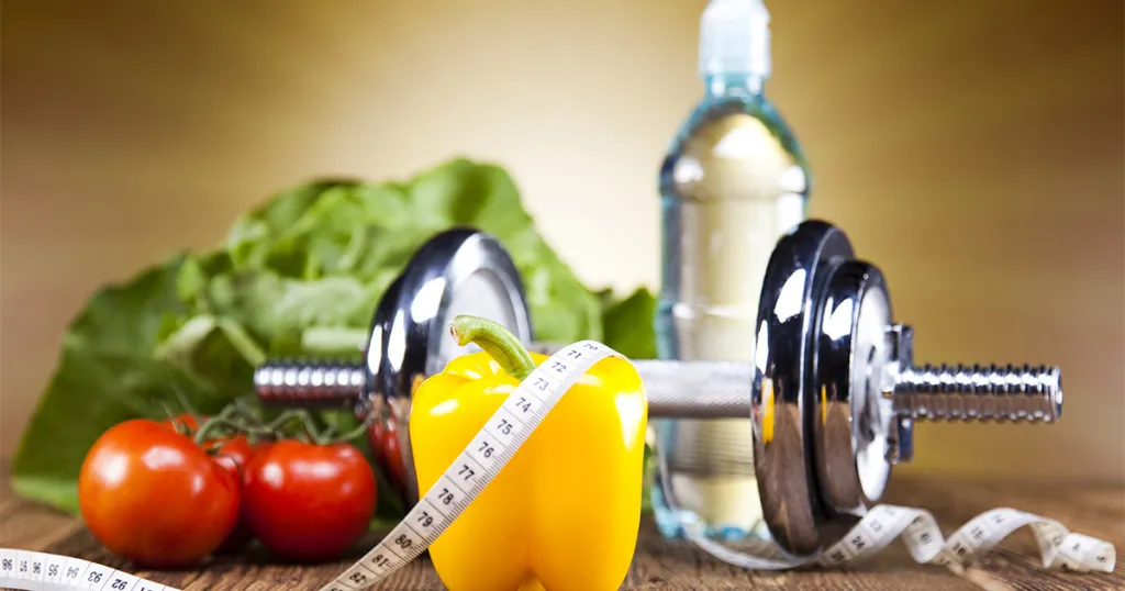 Foto halter, paprika, tomaat, meetlint, sla en water: een toolkit voor een gezonde leefstijl