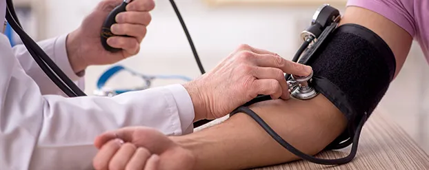 dokter meet bloeddruk op bij patient