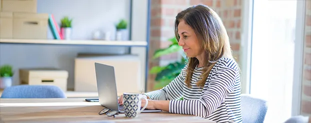 Vrouw aan tafel achter laptop
