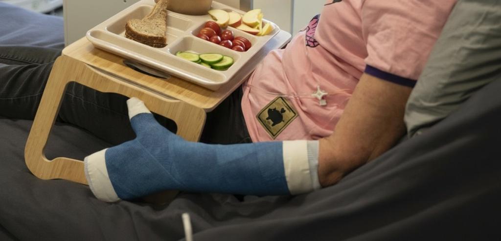 Iemand in ziekenhuisbed met gips om de arm en hand