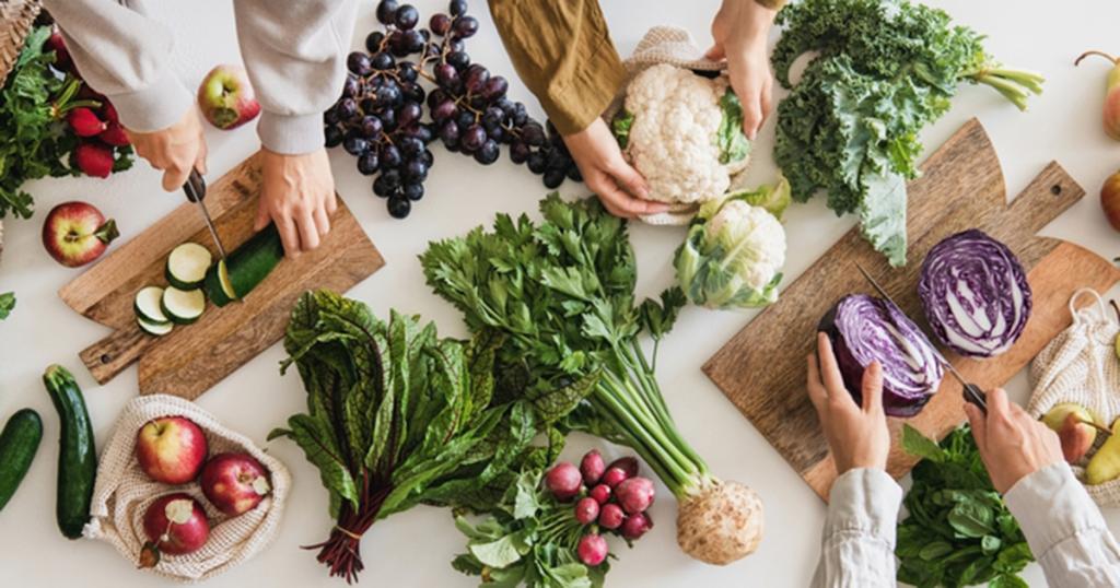 Handen die groentes snijden 