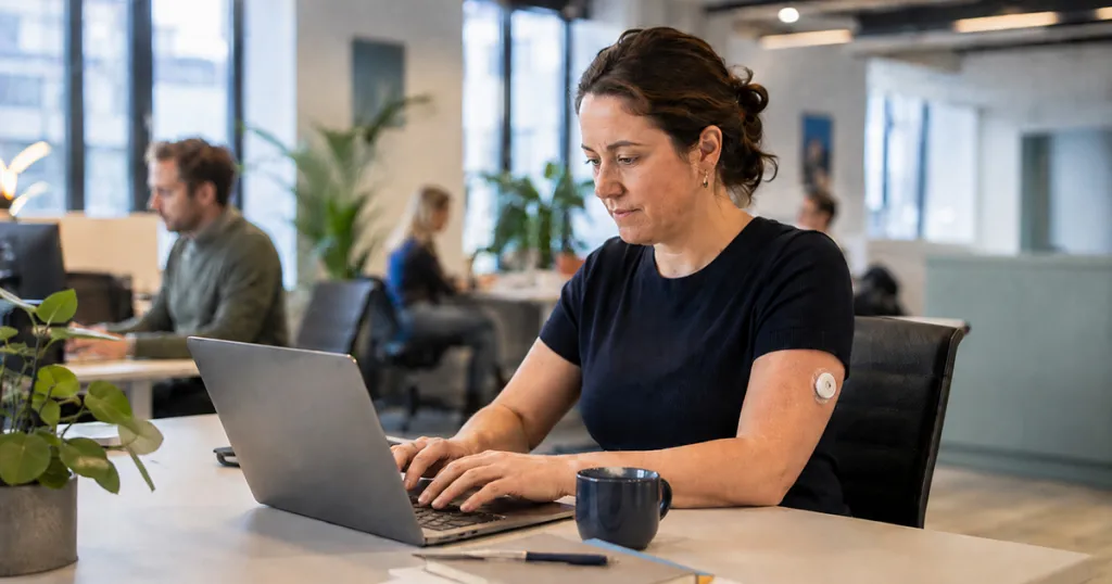 Foto: vrouw met diabetes type 1 werkt achter de laptop op kantoor