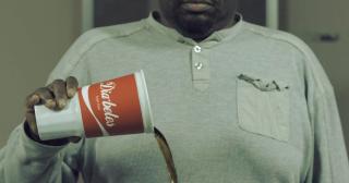 man giet beker met frisdrank leeg